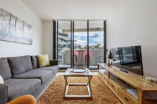 Una sala de estar con un sofá y un televisor. en Abbotsford Short Stay Luxury Style & Location, en Melbourne