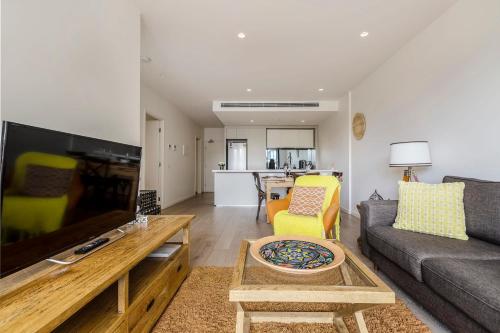 a living room with a couch and a tv at Abbotsford Short Stay Luxury Style & Location in Melbourne