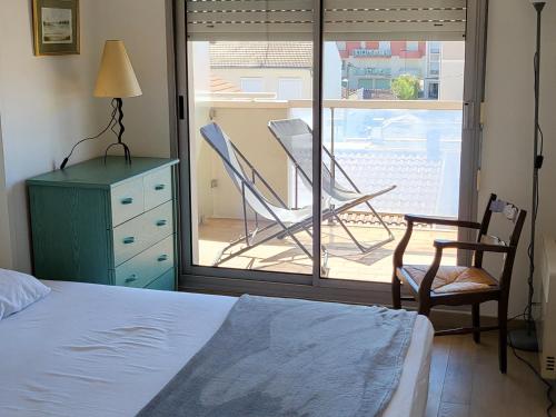 une chambre avec un lit, une chaise et une fenêtre dans l'établissement Appartement T2 en centre ville avec terrasse, wifi, Parking - FR-1-374-188, à Arcachon