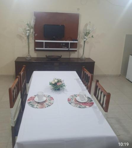 a table with a white tablecloth and two cups and chairs at Refugio de los llanos in Chamical