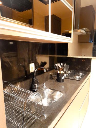 a kitchen counter with a sink and a stove at Apto novo no centro in Pomerode