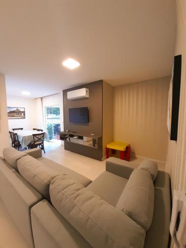 a living room with a couch and a tv at Apto novo no centro in Pomerode