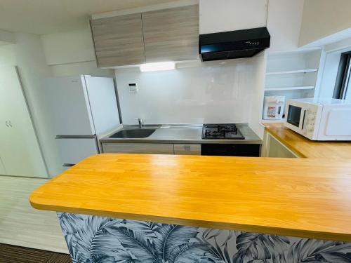 a kitchen with a wooden counter top and a microwave at ROYAL YONEGAHAMA ｌ米が浜通 in Kusugaurachō