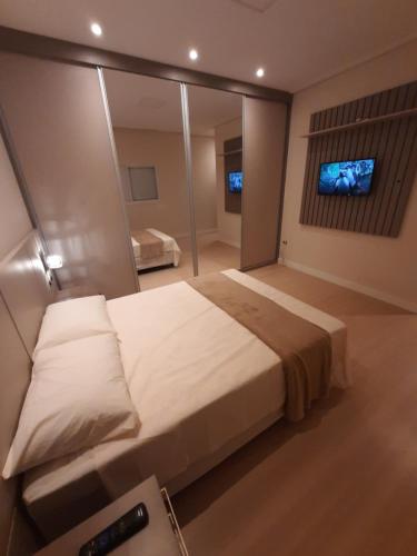 ein Schlafzimmer mit einem großen Bett und einem Spiegel in der Unterkunft HillTop Serra da Mantiqueira in Sapucaí-Mirim