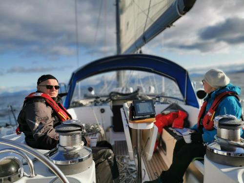 twee mannen op de boeg van een boot bij Liveaboard sailing tour in Harstad islands in Harstad