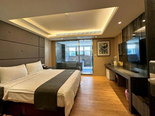 和平区にあるMing Zhi Hot Spring Hotel Building B Dongguan Hot Spring Hotelの大きなベッドとテレビのある寝室