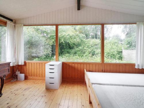 1 dormitorio con cama y ventana grande en Holiday home Melby IX, en Melby