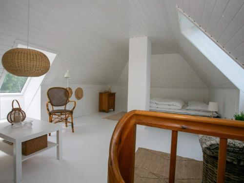 a attic room with a bed and a table at Holiday home Rudkøbing XX in Rudkøbing