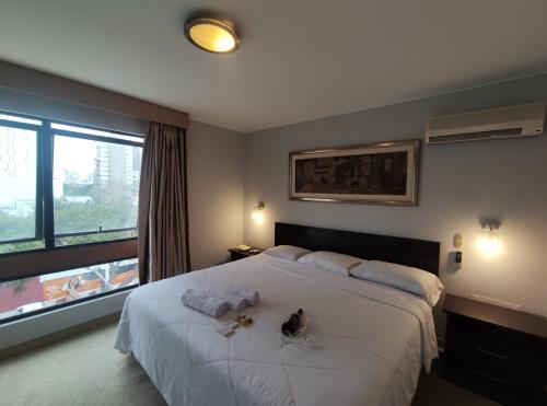 リマにあるInti Llaqta Hotel & Suitesのベッドルーム(大きな白いベッド1台、窓付)