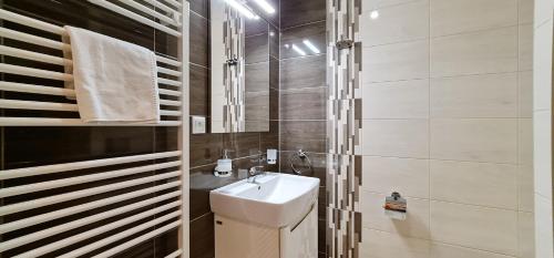 a white bathroom with a sink and a toilet at LUXURY Apartment Hrebienok D210 in Smokovce