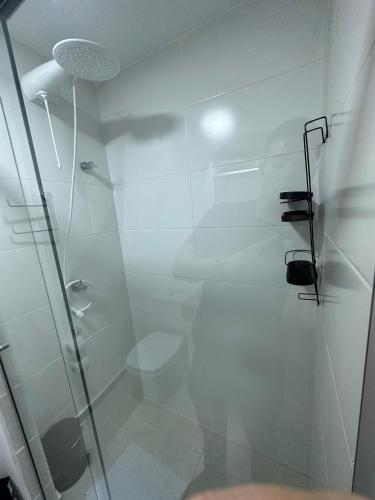 a bathroom with a glass shower with a toilet at Studio Be Happy! piscina academia coz completa in Juiz de Fora