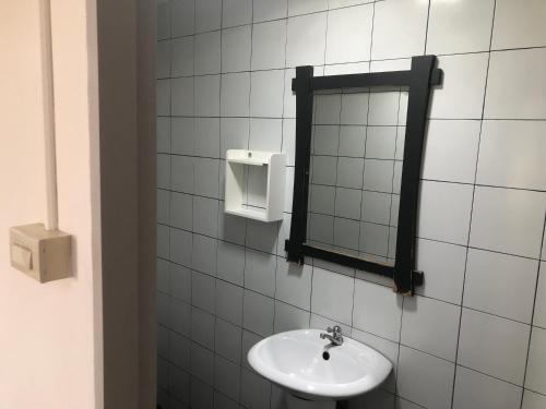 a white tiled bathroom with a sink and a mirror at Bluemoon 5 minutes walk to the beach in Ko Samed