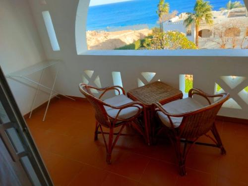 una mesa y sillas con vistas a la playa en Domina coral bay Sultan - private room, en Sharm El Sheikh