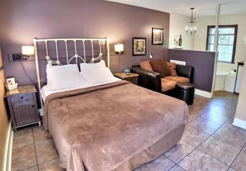 a bedroom with a large bed and a living room at D'vinery Rock Cottage/ #6 in Eureka Springs