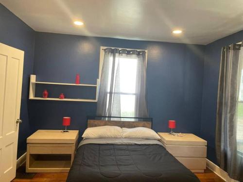 - une chambre avec des murs bleus et un lit avec deux lampes dans l'établissement fashionably cozy place, à Meriden