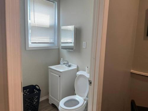 a bathroom with a white toilet and a window at fashionably cozy place in Meriden
