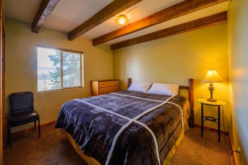 a bedroom with a bed and a chair and a window at Strawberry Fields in Duck Creek Village