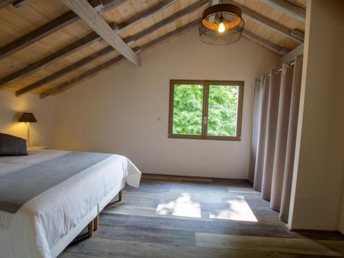 a bedroom with a bed and a window at Maison Authentique avec Piscine, Étang Privatif et Confort Moderne en Dordogne - FR-1-616-332 in Agonac