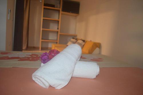 stos ręczników na łóżku w pokoju w obiekcie Kai Palmer Lodge w mieście Punaauia