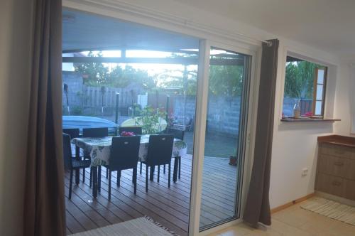 a sliding glass door leading to a patio with a table at Kai Palmer Lodge in Punaauia