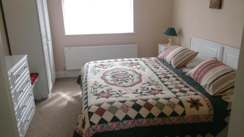 a bedroom with a bed with a quilt on it at Villa Pio Luxury Apartment 3km from historic Cong, Ashford Castle, Ashford Lodge in Cong