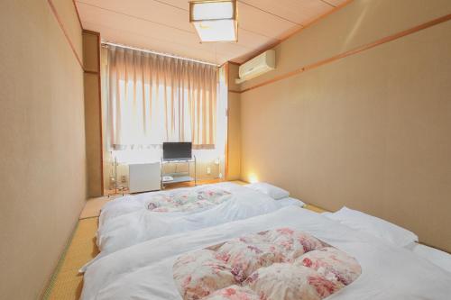 a room with a large bed with a window at Tabist Setouchinoyado Takehara Seaside in Takekara