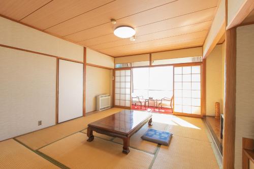 a room with a table in the middle of a room at Tabist Setouchinoyado Takehara Seaside in Takekara