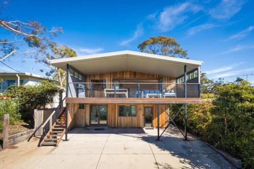 a house with a large deck and a balcony at Beachwood - Pambula Beach in Pambula Beach