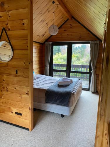 a bedroom with a bed in a wooden house at Dakune Chill - The Chalet in Ohakune