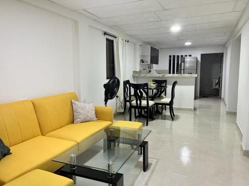 a living room with a yellow couch and a table at hostal la niña carmen in Cartagena de Indias