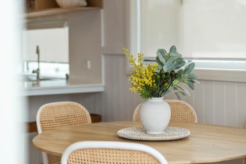 a vase of flowers sitting on a wooden table at Ingenia Holidays Merry Beach in Kioloa