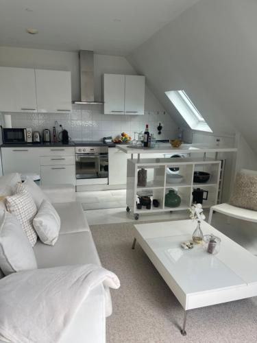 un salon blanc avec un canapé et une table dans l'établissement La suite Monceau, à Paris