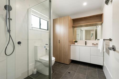 a bathroom with a shower and a toilet and a sink at Ingenia Holidays Merry Beach in Kioloa
