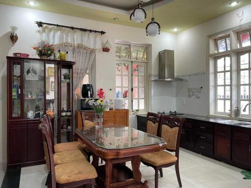 a kitchen with a glass table and some chairs at villa Nga Hoàng Đà lạt in Da Lat