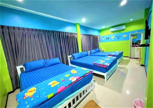 two beds in a room with blue and green walls at บ้านพักชะอำ Dream​ ​& Dear​ Fantasy​ Pool​ Villa​ Cha-am in Ban Sa