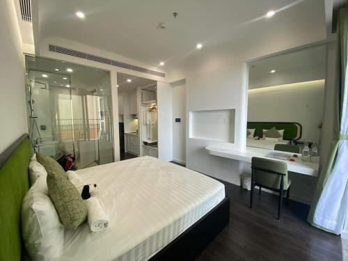 a bedroom with a large white bed and a desk at Loving family in Phu Quoc