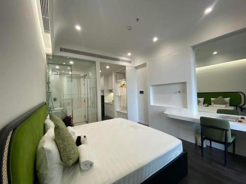a bedroom with a large white bed with a green wall at Loving family in Phu Quoc