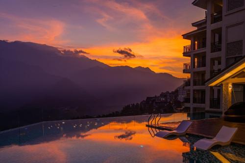 a view of a lake at sunset with buildings at Bamboo Sapa Hotel in Sapa
