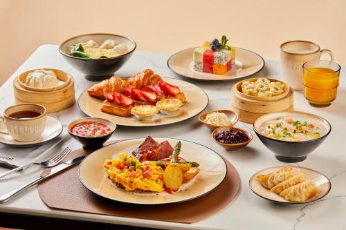 a table with plates of food and bowls of food at Sheraton Guangzhou Hotel in Guangzhou