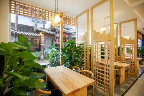 un restaurante con una mesa de madera y algunas plantas en 武陵山水客栈Wuling Shanshui Hotel, en Zhangjiajie