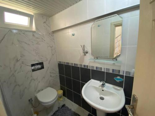 a bathroom with a sink and a toilet and a mirror at Turkish riviera sea view detached villa in Gazipasa
