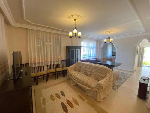 - un salon avec un canapé et une salle à manger dans l'établissement Turkish riviera sea view detached villa, à Gazipaşa