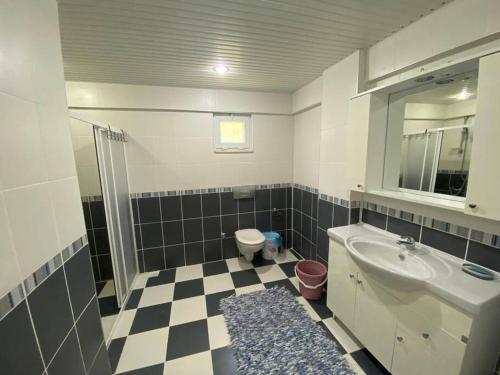 a bathroom with a black and white checkered floor at Turkish riviera sea view detached villa in Gazipasa