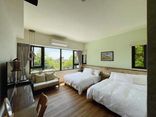 a bedroom with two beds and a couch and windows at Taroko 767 Farm B&B 太魯閣767農莊民宿 in Xiulin