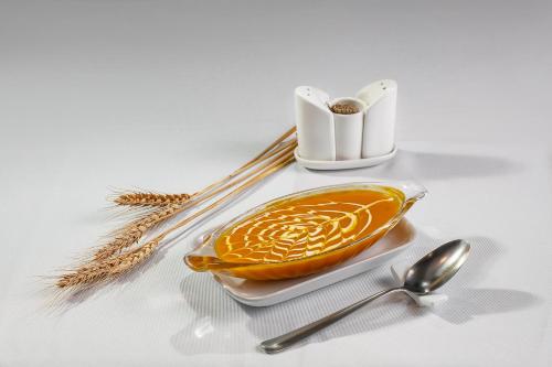 a plate with an orange on a table with spoons at Bamboo Sapa Hotel in Sa Pa