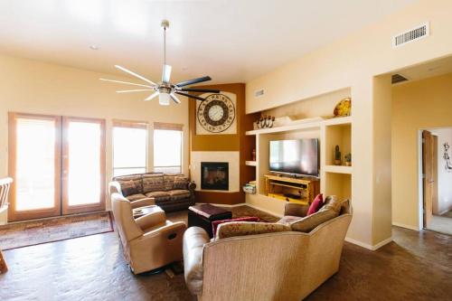 a living room with two couches and a clock on the wall at Sprawling Arizona Oasis w/ Dream Backyard in Anthem