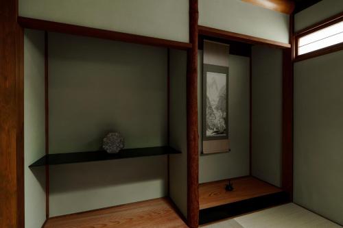 a corner of a room with shelves and a window at hotori in Kyoto