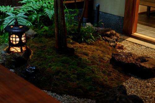 a garden with a lantern sitting in the grass at hotori in Kyoto