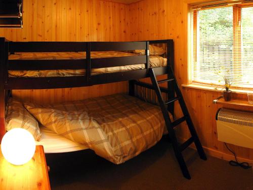 An Carraig Log Cabin في ستراثير: غرفة نوم مع سريرين بطابقين في كابينة