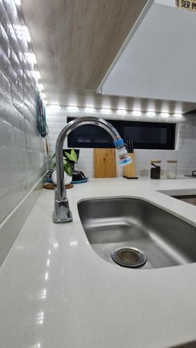 um lavatório de cozinha com uma torneira no balcão em Home Eliz El espacio perfecto em Cartago